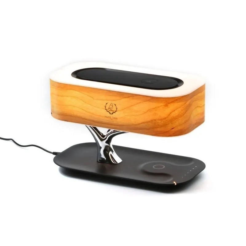 Creative tree light table lamp with natural cherry veneer shade, Bluetooth speaker, and wireless charging on a bedside table