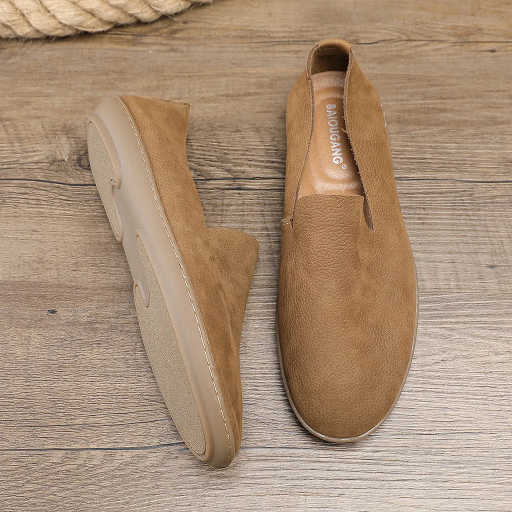 Handmade grey men's low-top leather shoes with a flat wedge rubber sole on a plain background.