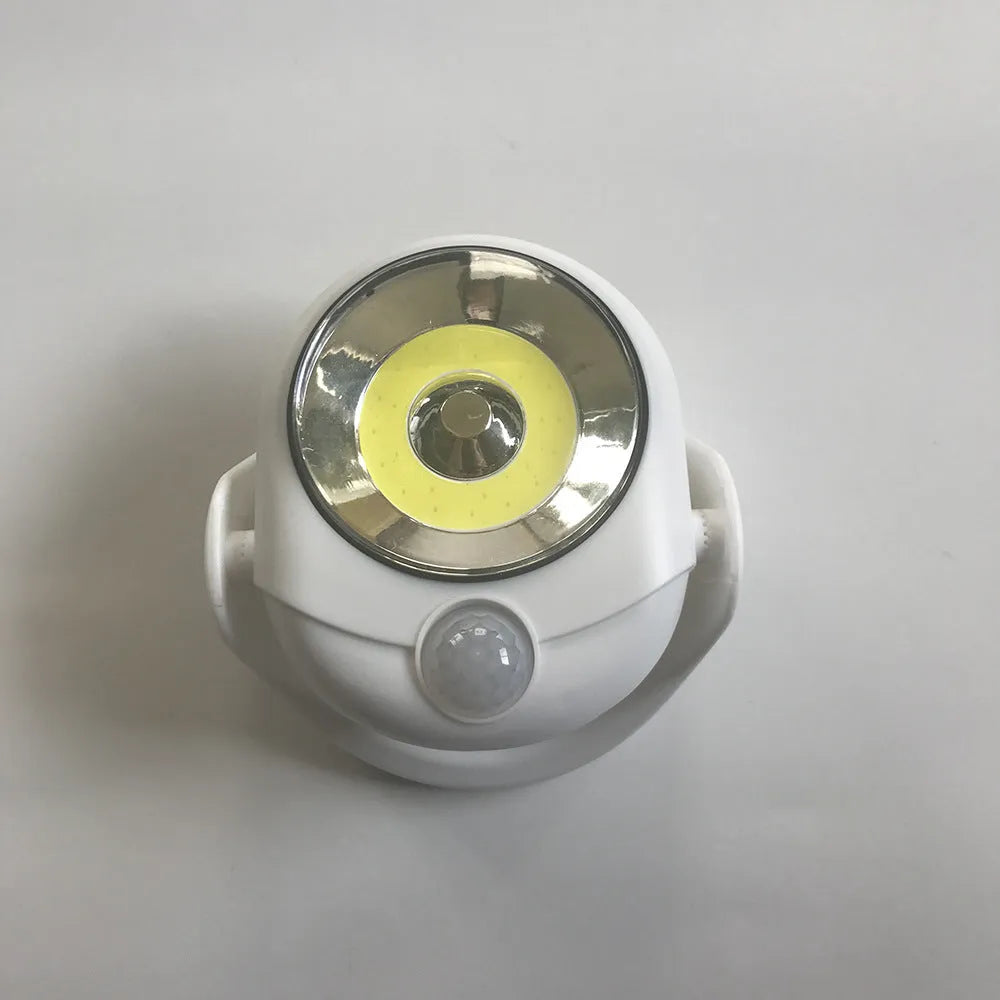 White Atomic Angel induction light unit on a surface showing its compact size.