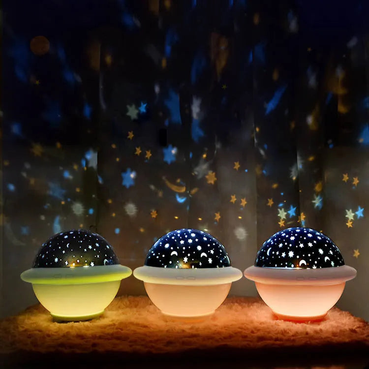 UFO-shaped plastic starry sky projection night light in pink on a wooden surface