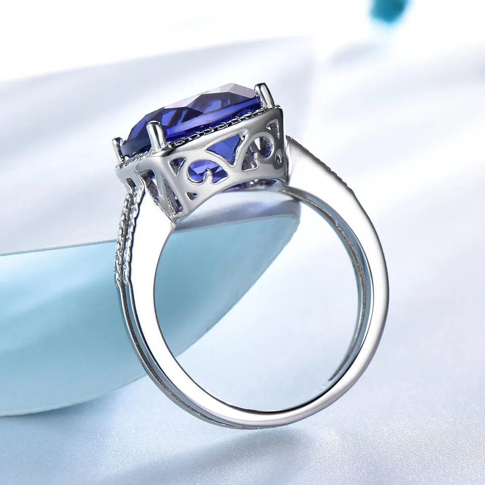 Women's sterling silver ring with a blue tanzanite gemstone on a polished band.