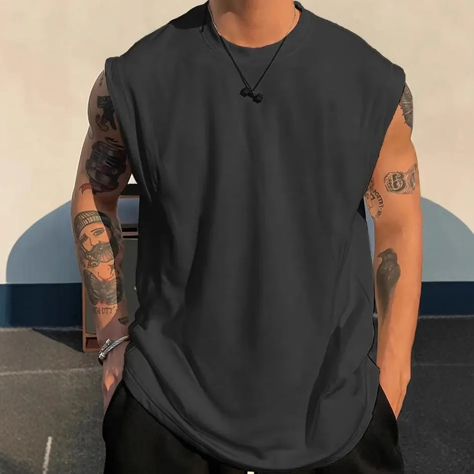 Man wearing a loose, solid-colour cotton sleeveless tank top in a casual setting.