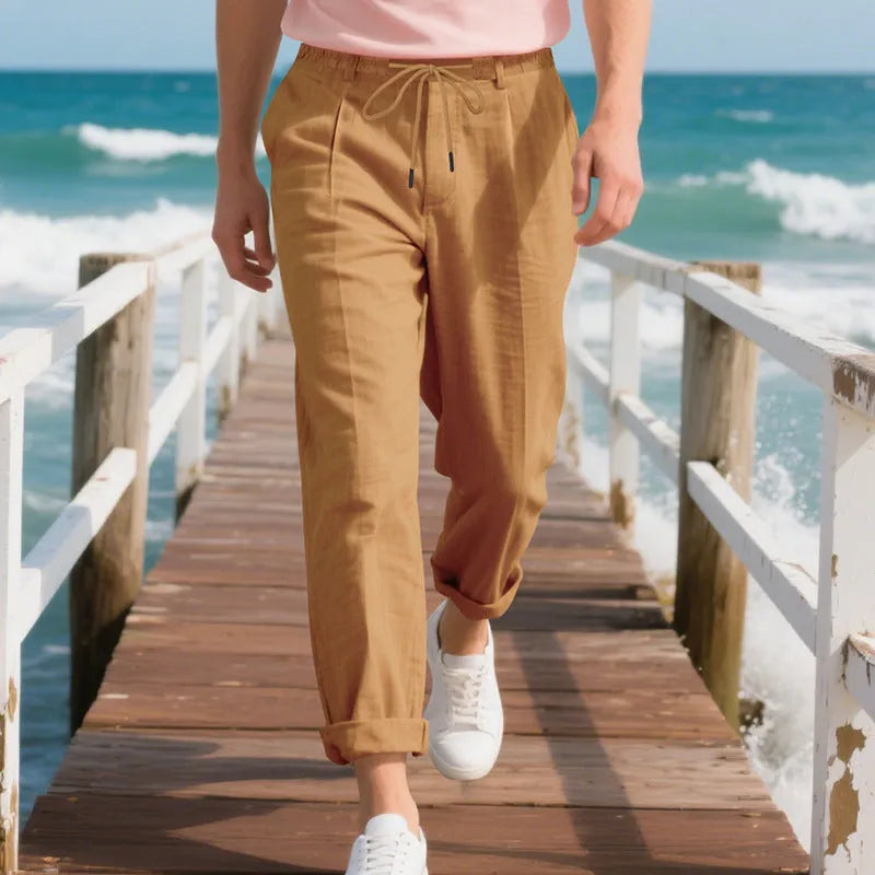 Men's light beige linen casual trousers with drawstring waist and straight-leg fit on a hanger.