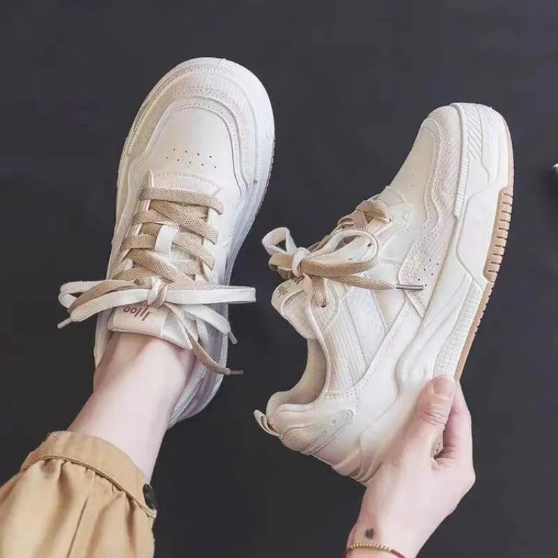 Pink and beige low-top sneakers with a rubber sole and imitation leather upper.