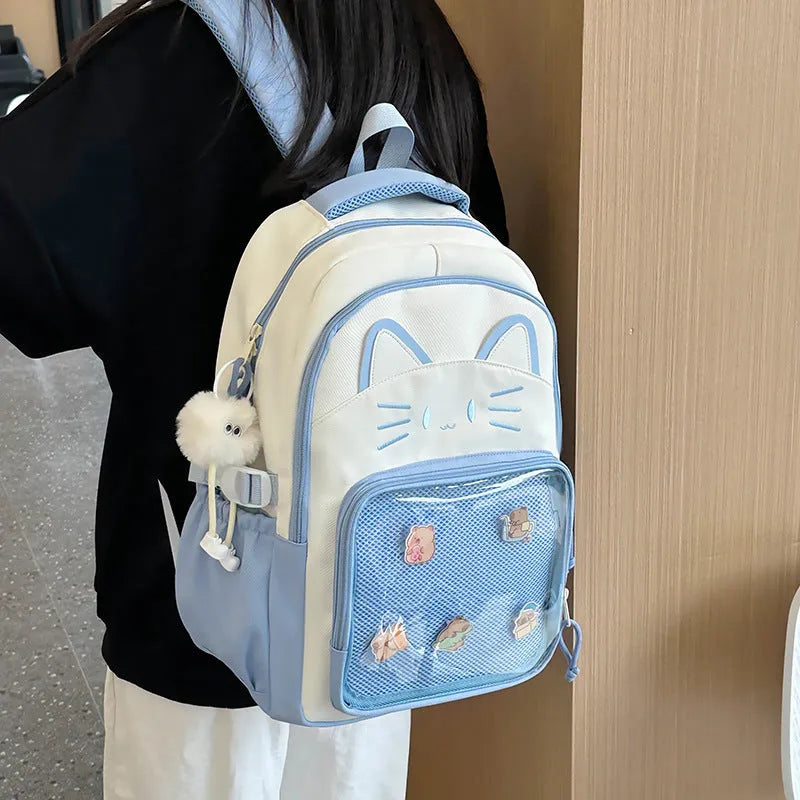 Cartoon print large capacity nylon backpack in pink with badge pendant, shown with curved shoulder straps.