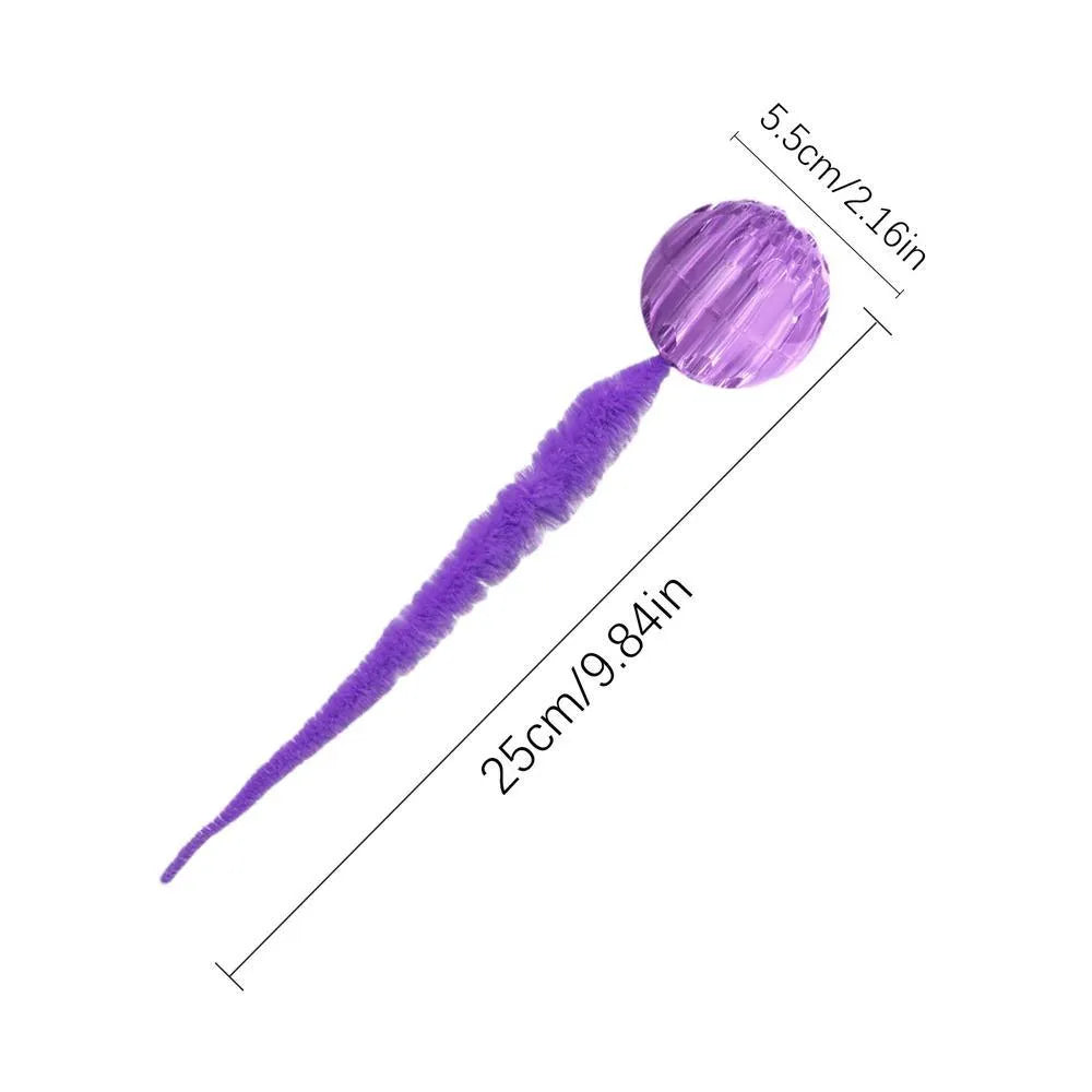 Interactive cat toy with purple bouncy ball and plush tail on wooden floor