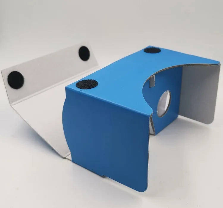 Pink and white cardboard VR glasses headset for smartphones, showing lenses, head strap, and magnetic button.