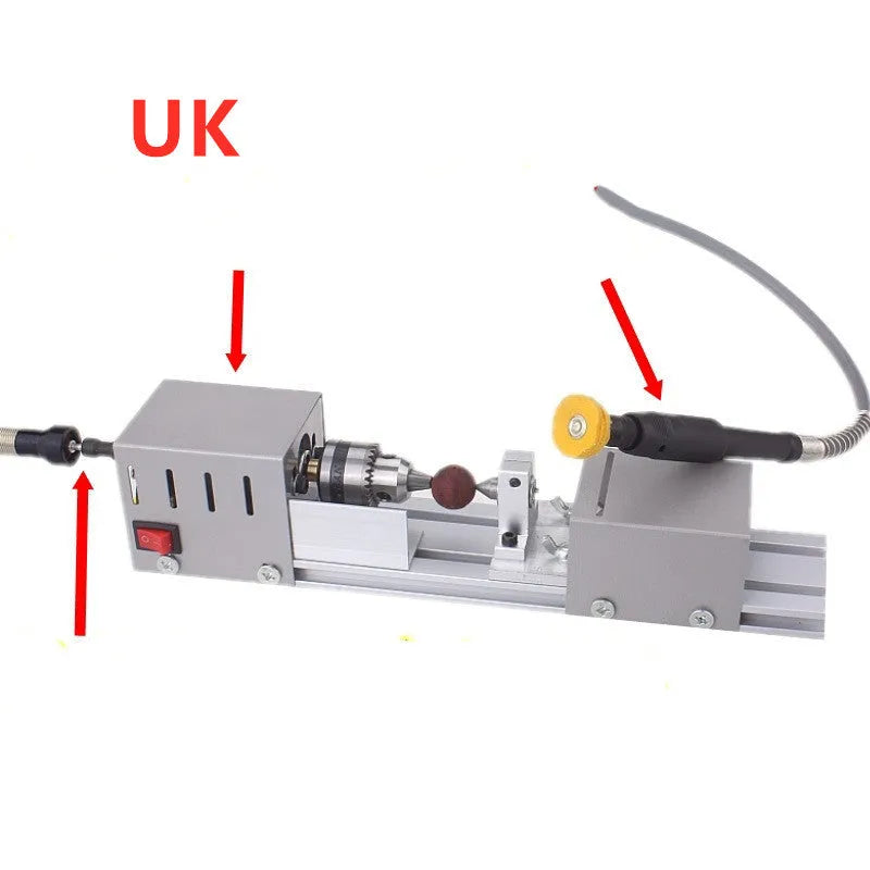 Silver metal mini woodworking lathe on a bench with carving knives and accessories.
