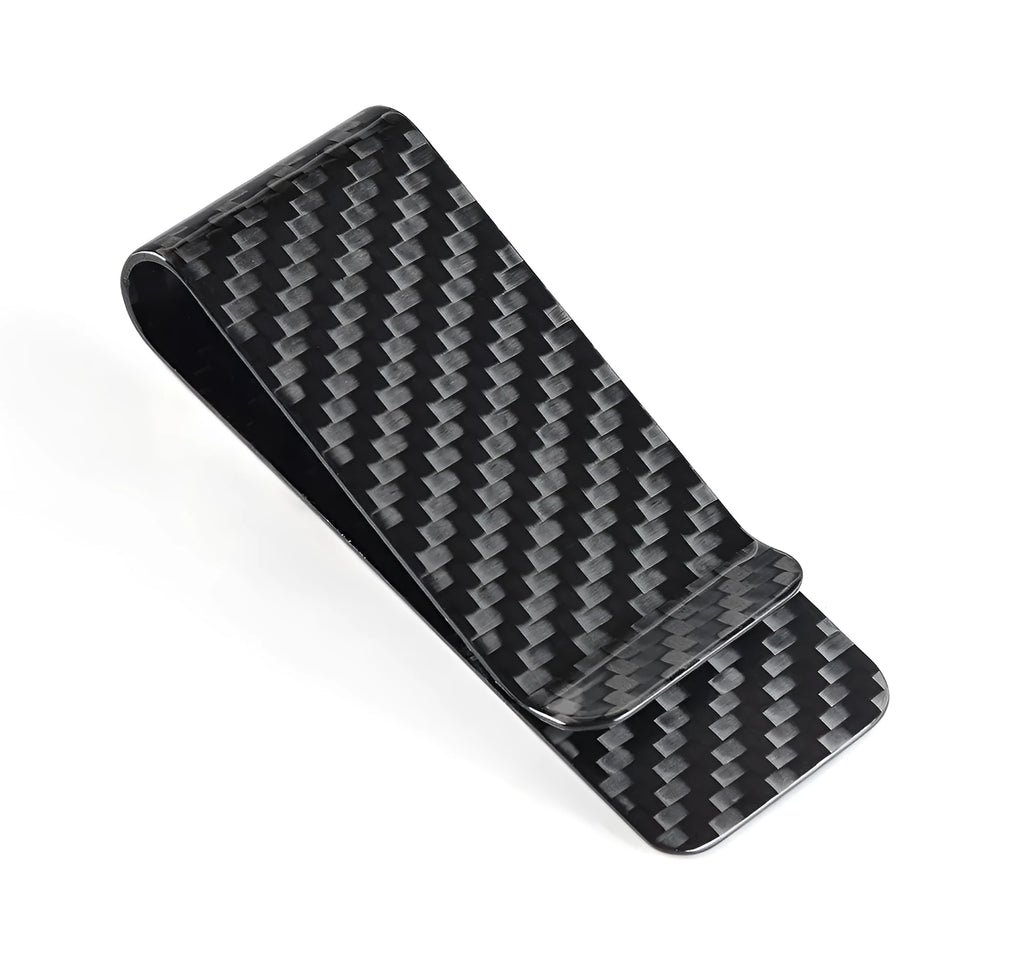 Black genuine carbon fiber money clip with striped glossy surface on a plain background