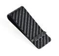 Black genuine carbon fiber money clip with striped glossy surface on a plain background