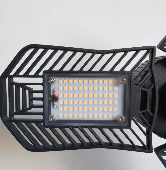 Waterproof industrial foldable LED garage lamp with die-cast aluminium housing shown in a workshop setting.