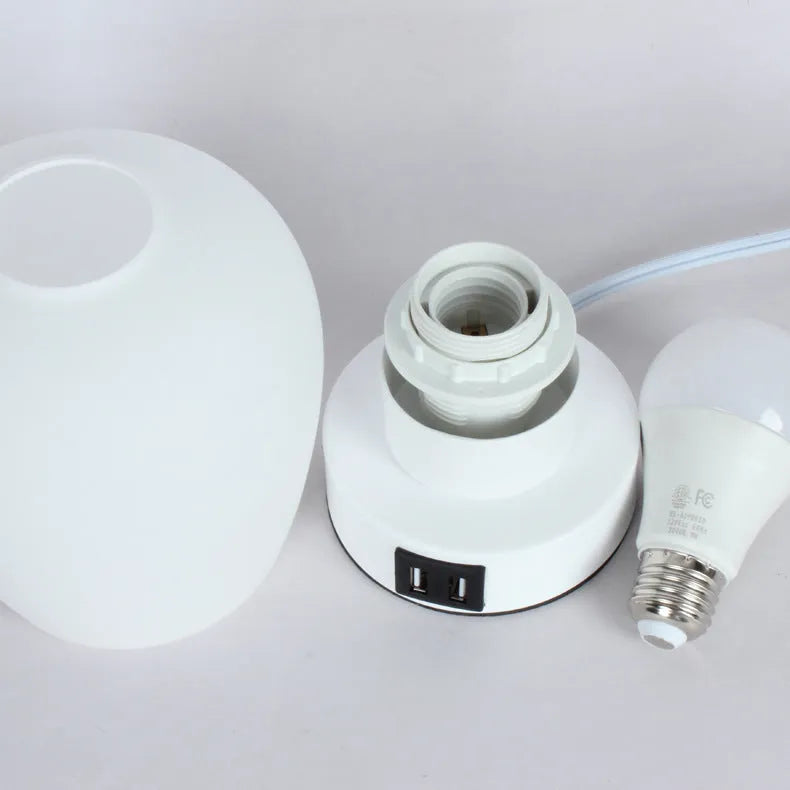 Nordic touch glass desk lamp with three colour settings and USB port on bedside table