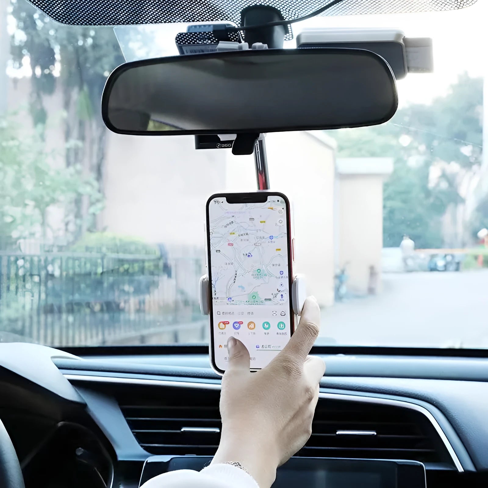 Black ABS plastic mobile phone bracket mounted on vehicle rearview mirror holding smartphone