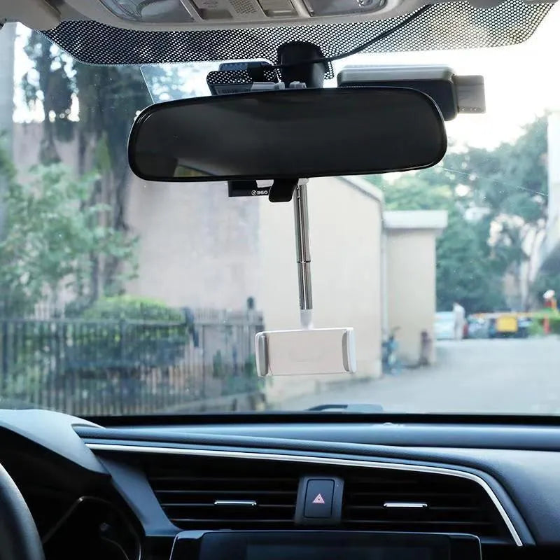 Black ABS plastic mobile phone bracket mounted on vehicle rearview mirror holding smartphone