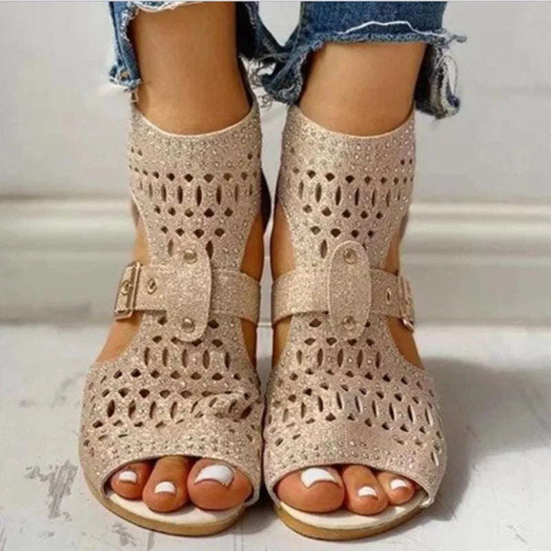 Women's beige flat sandals with wedge heel, rivet detail, and back zipper.
