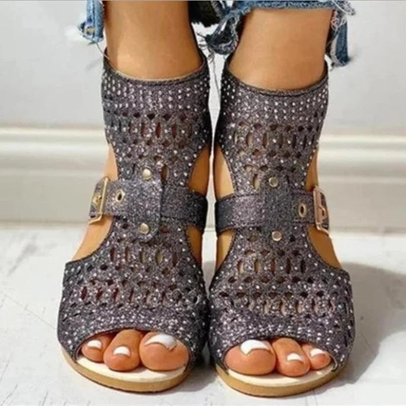 Women's beige flat sandals with wedge heel, rivet detail, and back zipper.
