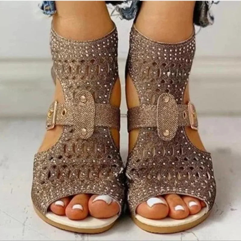 Women's beige flat sandals with wedge heel, rivet detail, and back zipper.