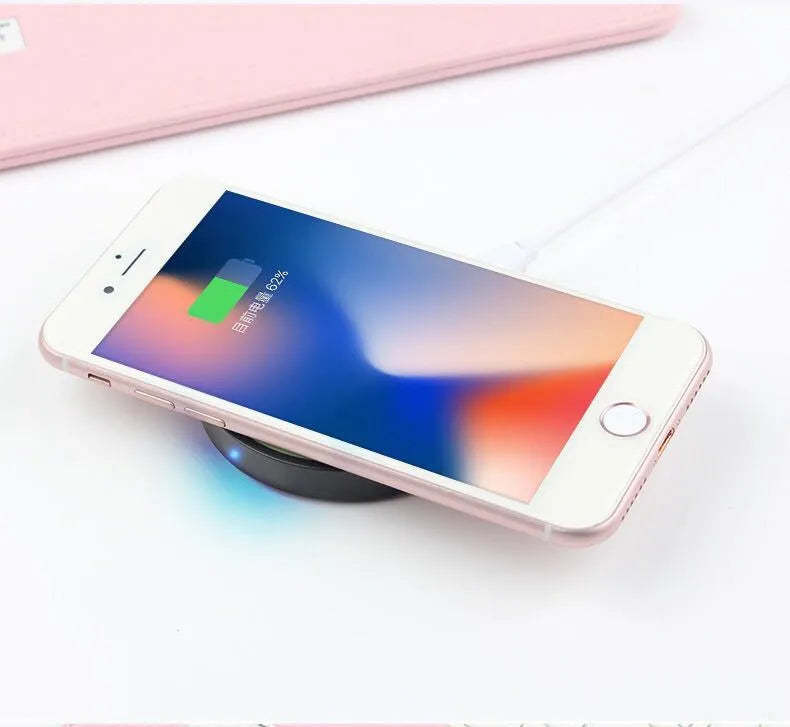 Square Qi wireless charging base for mobile phones in one of six colours on a desk.