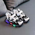 Children's bright light sports sneakers with mesh panels and Velcro strap in black, grey, or pink.
