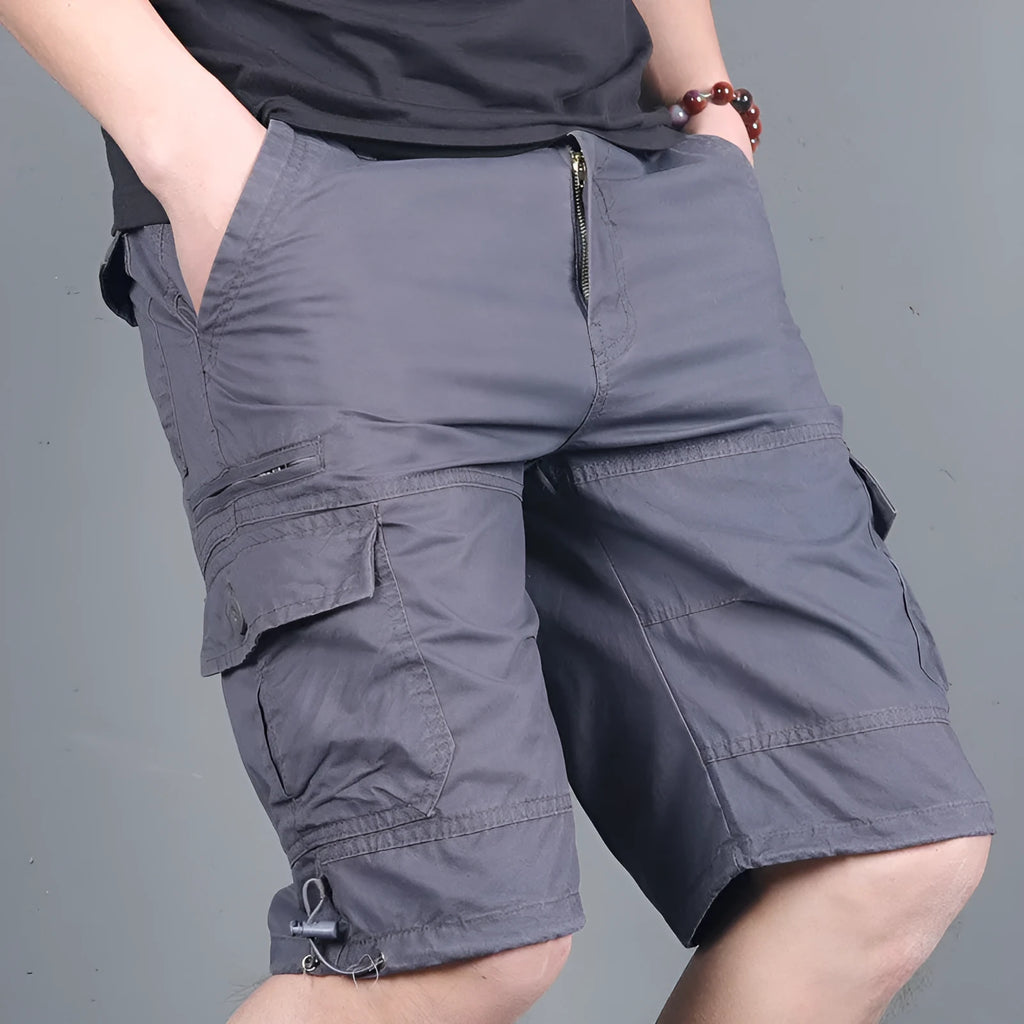 Green multi-pocket cotton cargo shorts with visible zippered side pocket, flat lay on white background