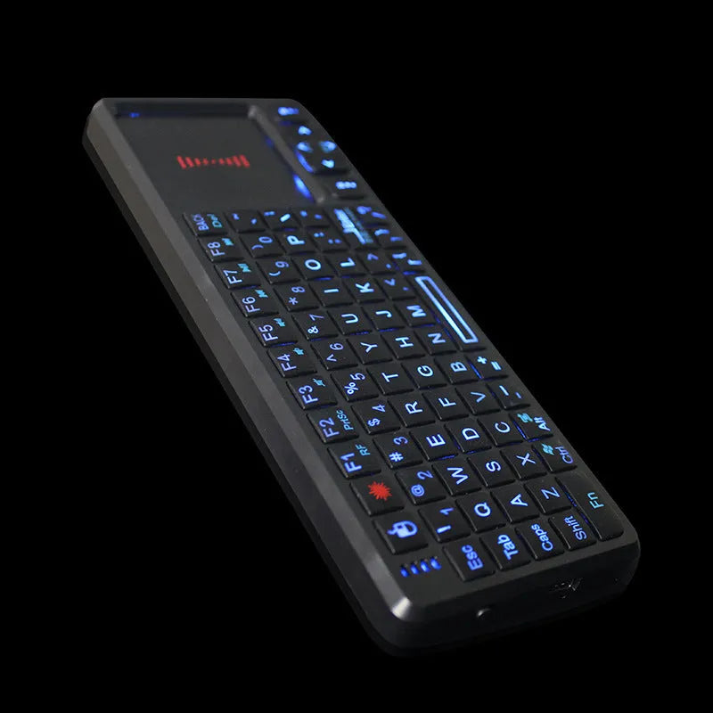 Black wireless mini keyboard with touch screen and optical mouse on a desk.