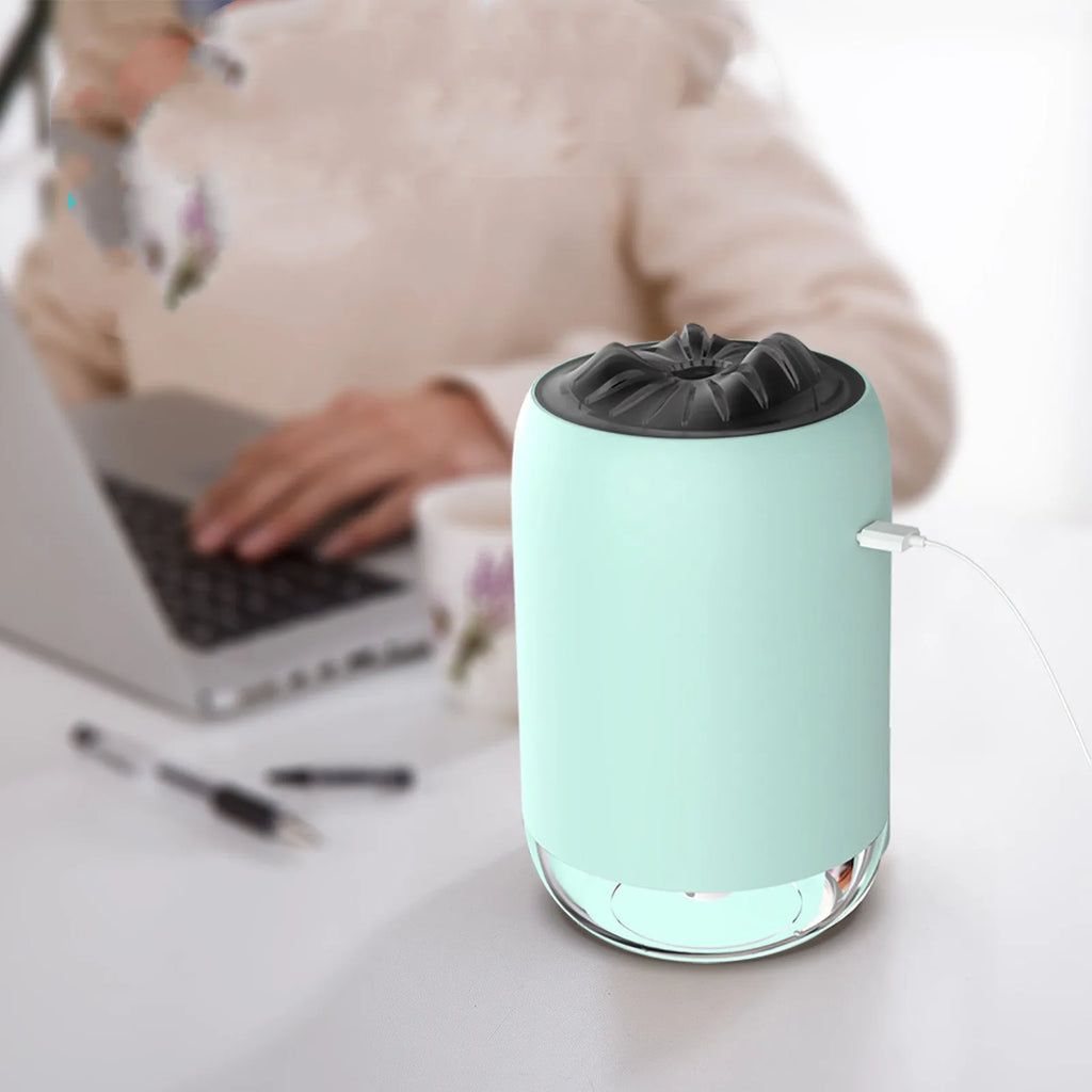 White Magic Flame columnar ultrasonic humidifier with USB cable on a wooden desk.