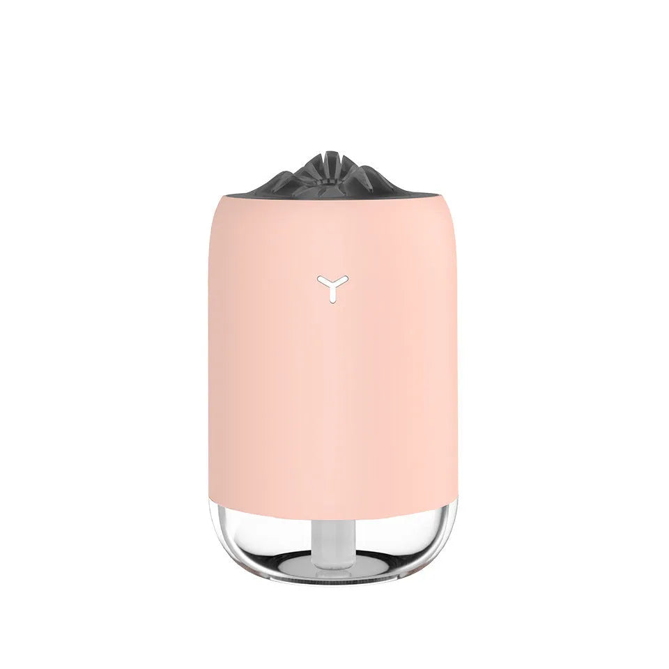 White Magic Flame columnar ultrasonic humidifier with USB cable on a wooden desk.