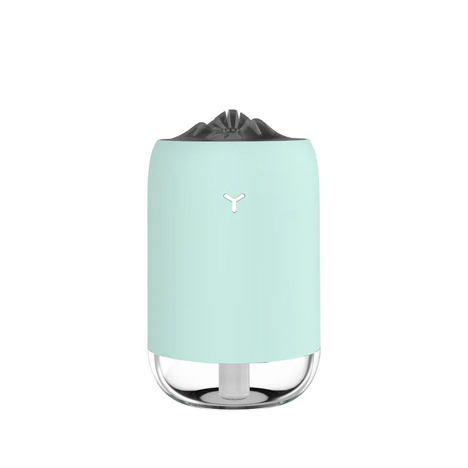 White Magic Flame columnar ultrasonic humidifier with USB cable on a wooden desk.