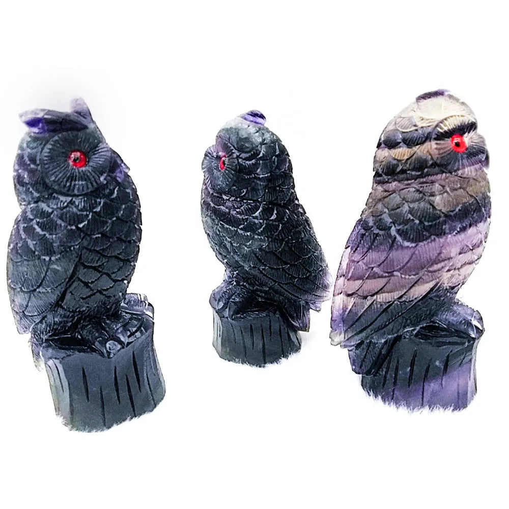 Hand-carved purple fluorite owl ornament on neutral background showing natural stone colouration