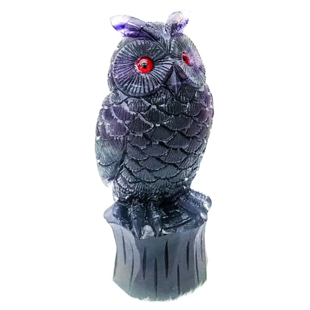 Hand-carved purple fluorite owl ornament on neutral background showing natural stone colouration