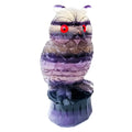 Hand-carved purple fluorite owl ornament on neutral background showing natural stone colouration