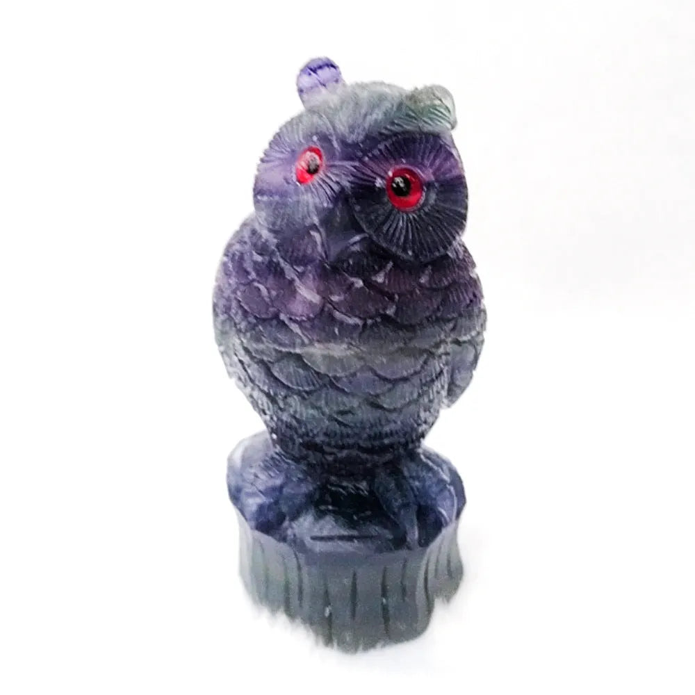 Hand-carved purple fluorite owl ornament on neutral background showing natural stone colouration
