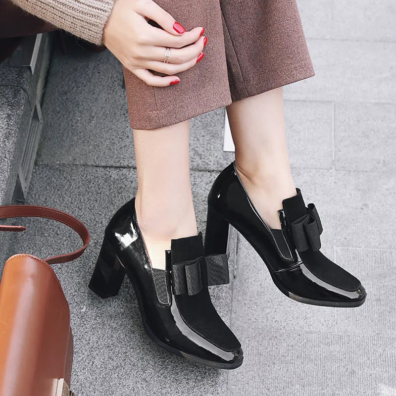 Women's black patent leather high heel with a thick square heel and rubber sole.