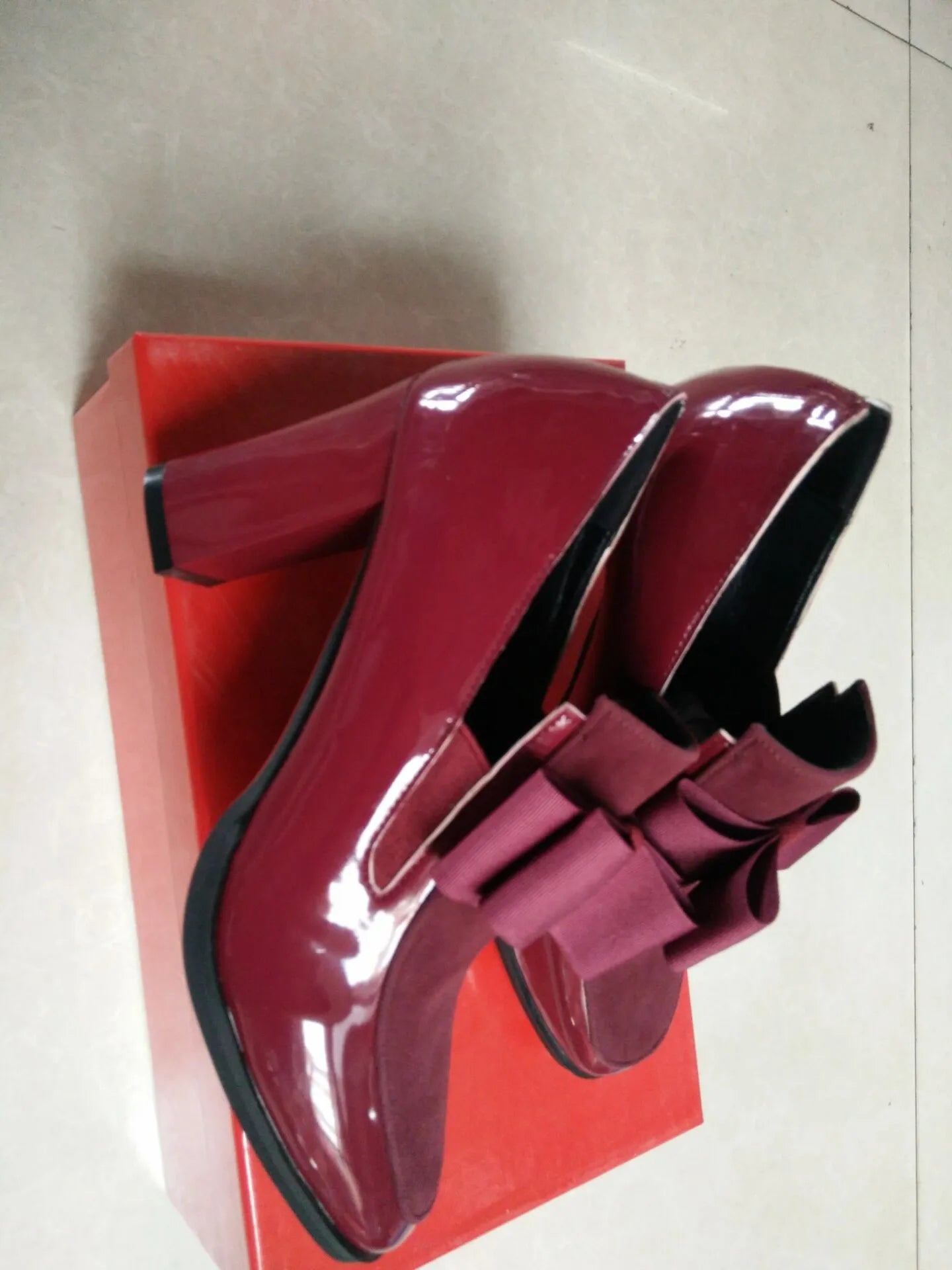 Women's black patent leather high heel with a thick square heel and rubber sole.
