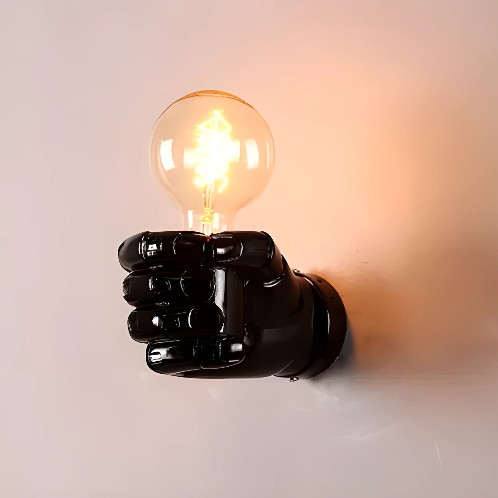 Creative fist-shaped resin wall lamp in black, mounted on a wall, for corridor or restaurant decoration.