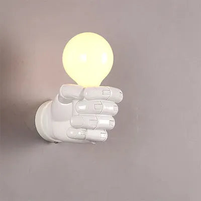 Creative fist-shaped resin wall lamp in black, mounted on a wall, for corridor or restaurant decoration.