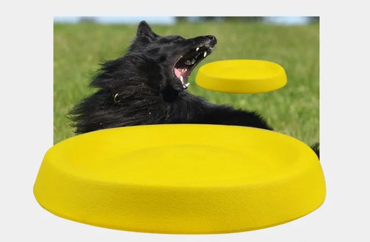 Bright yellow EVA plastic dog throwing toy for fetch games on a green lawn.