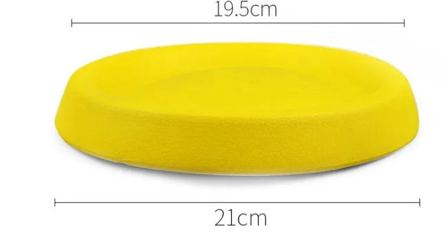 Bright yellow EVA plastic dog throwing toy for fetch games on a green lawn.