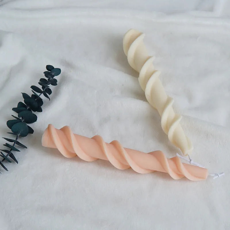 Handmade silicone candle mould with a spiral lace design for decorative wax candles.