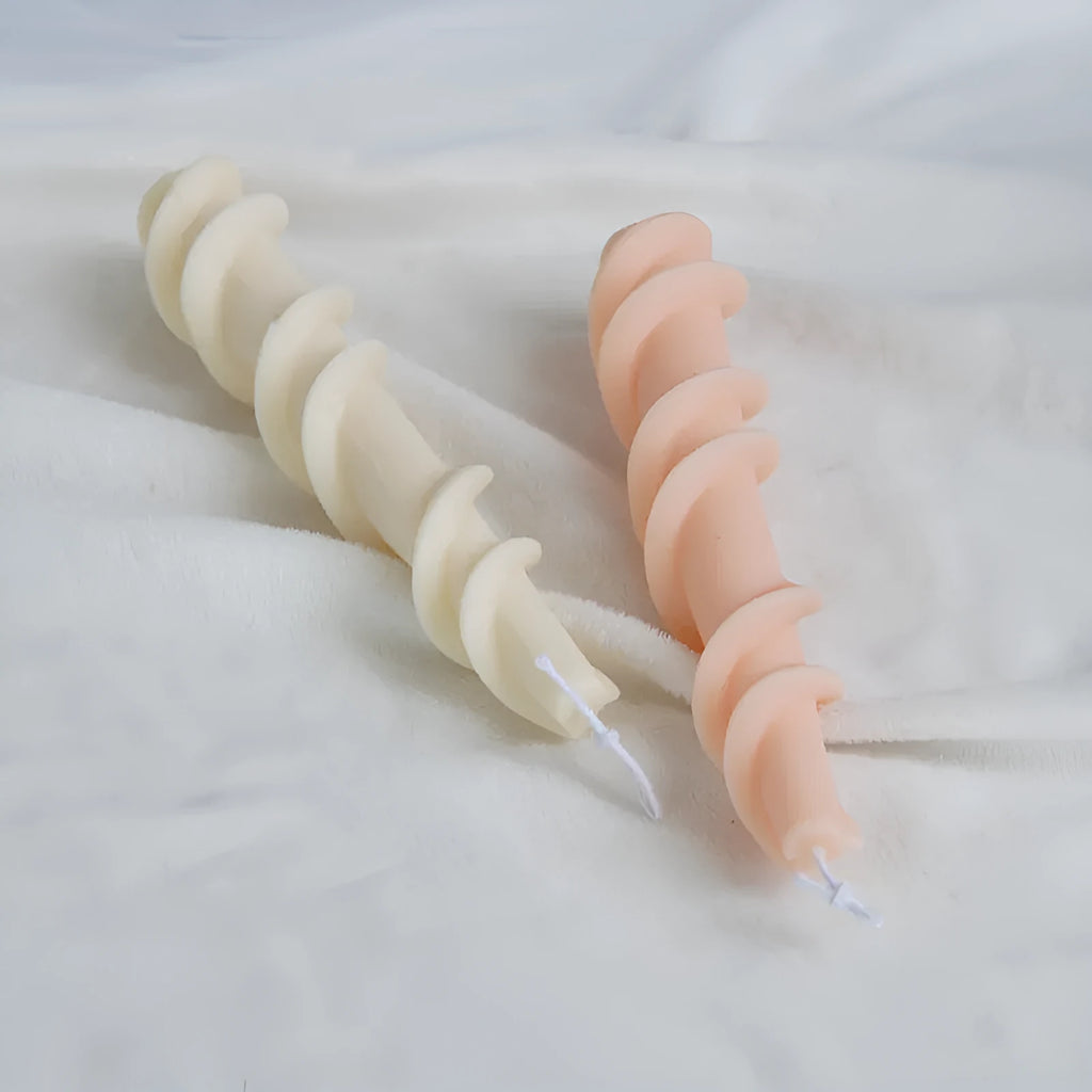 Handmade silicone candle mould with a spiral lace design for decorative wax candles.