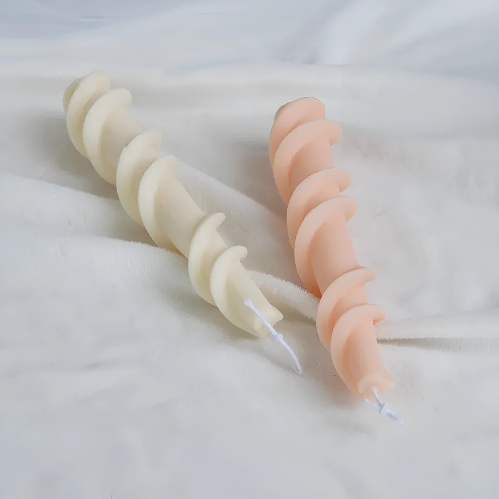 Handmade silicone candle mould with a spiral lace design for decorative wax candles.