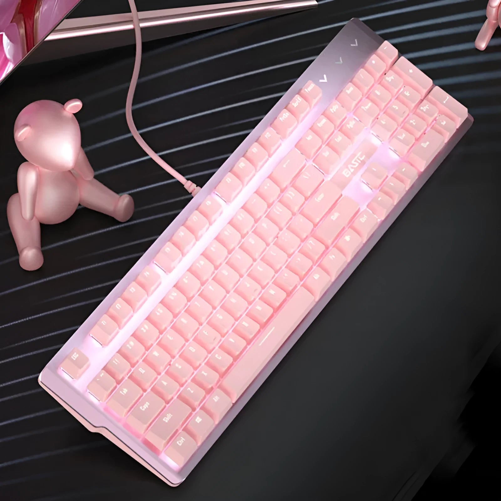 Pink wired mechanical keyboard and matching mouse set on a desk for E-sports gaming.