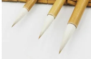 Set of three pure woolen hair Chinese calligraphy brushes with bamboo handles in large, medium and small sizes.