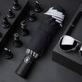 Black automatic reverse umbrella with folded canopy and non-slip plastic handle.