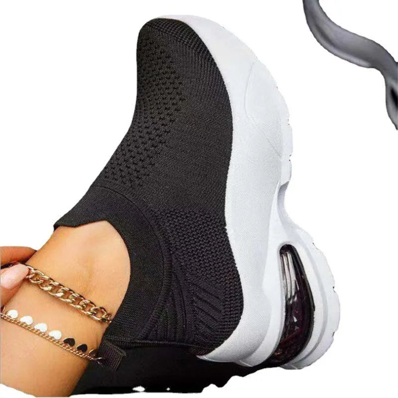 Women's white mesh sock-style sneakers with rubber sole on a plain background
