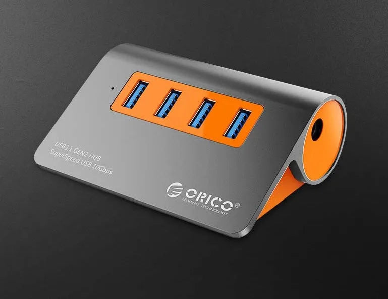 Dark grey aluminium USB-C hub with four USB 3.1 ports and orange accents beside detached 100cm cable