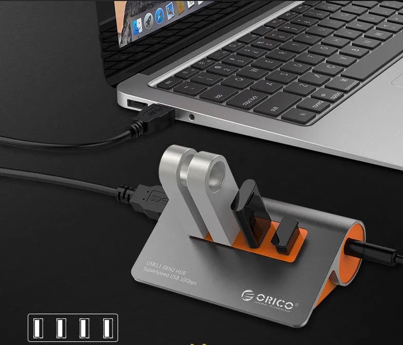 Dark grey aluminium USB-C hub with four USB 3.1 ports and orange accents beside detached 100cm cable