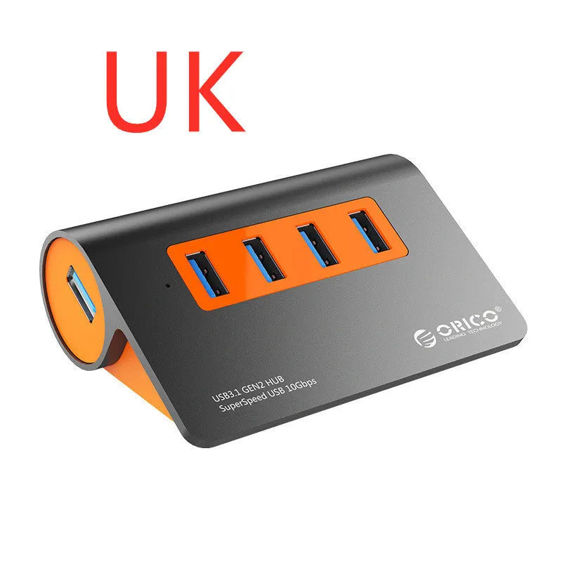 Dark grey aluminium USB-C hub with four USB 3.1 ports and orange accents beside detached 100cm cable