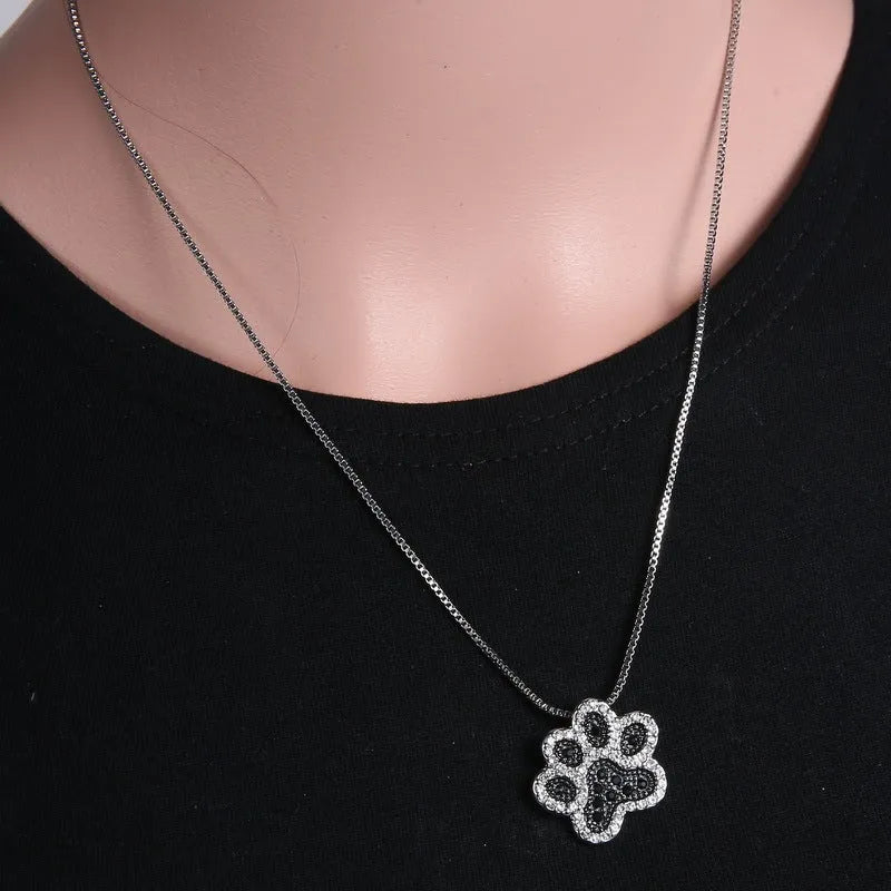 Alloy dog footprint pendant necklace with diamond-encrusted finish on light background