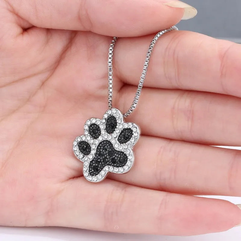 Alloy dog footprint pendant necklace with diamond-encrusted finish on light background